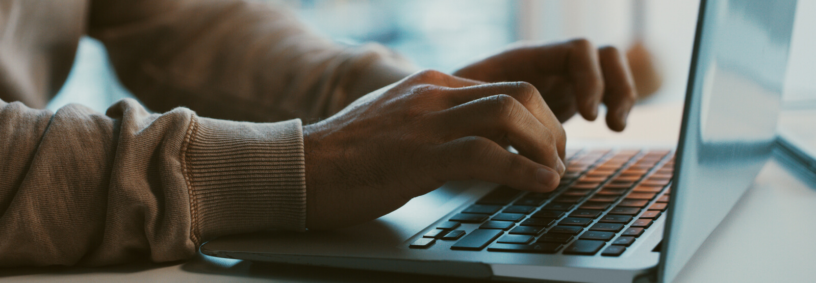 Close up of hands typing on a laptop